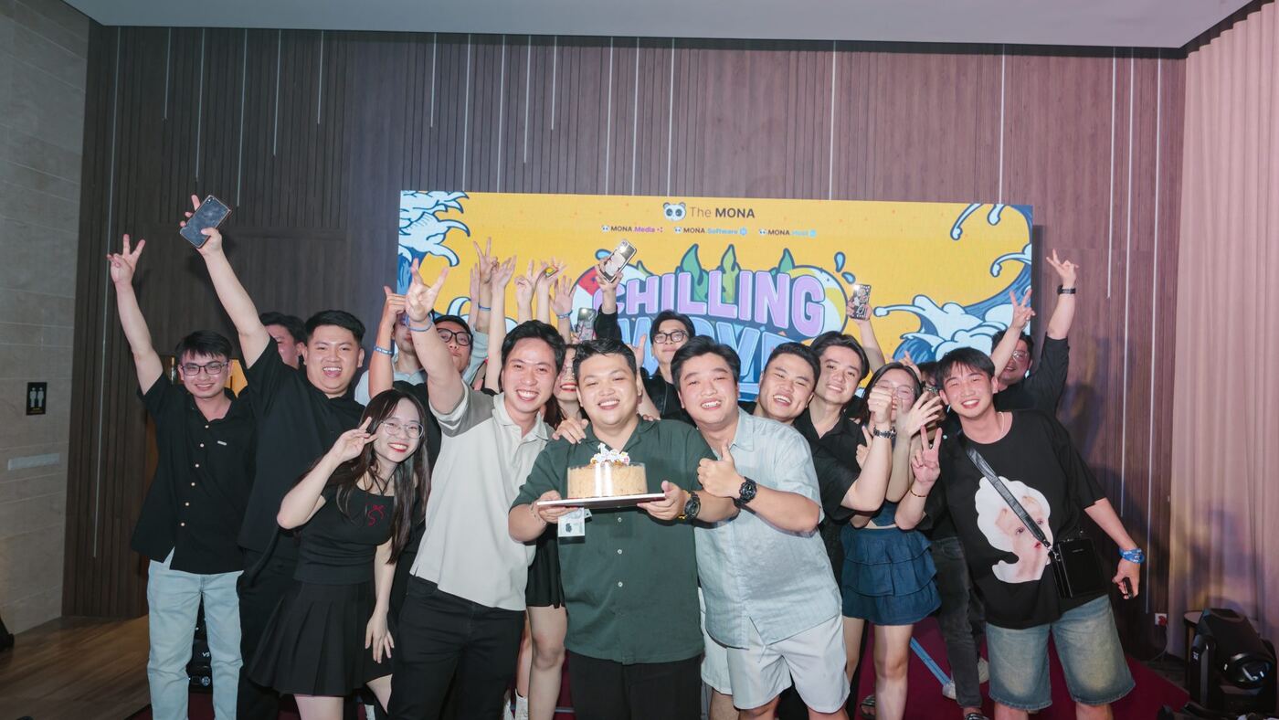 Đội ngũ MONA mừng sinh nhật trước phông chương trình team building
